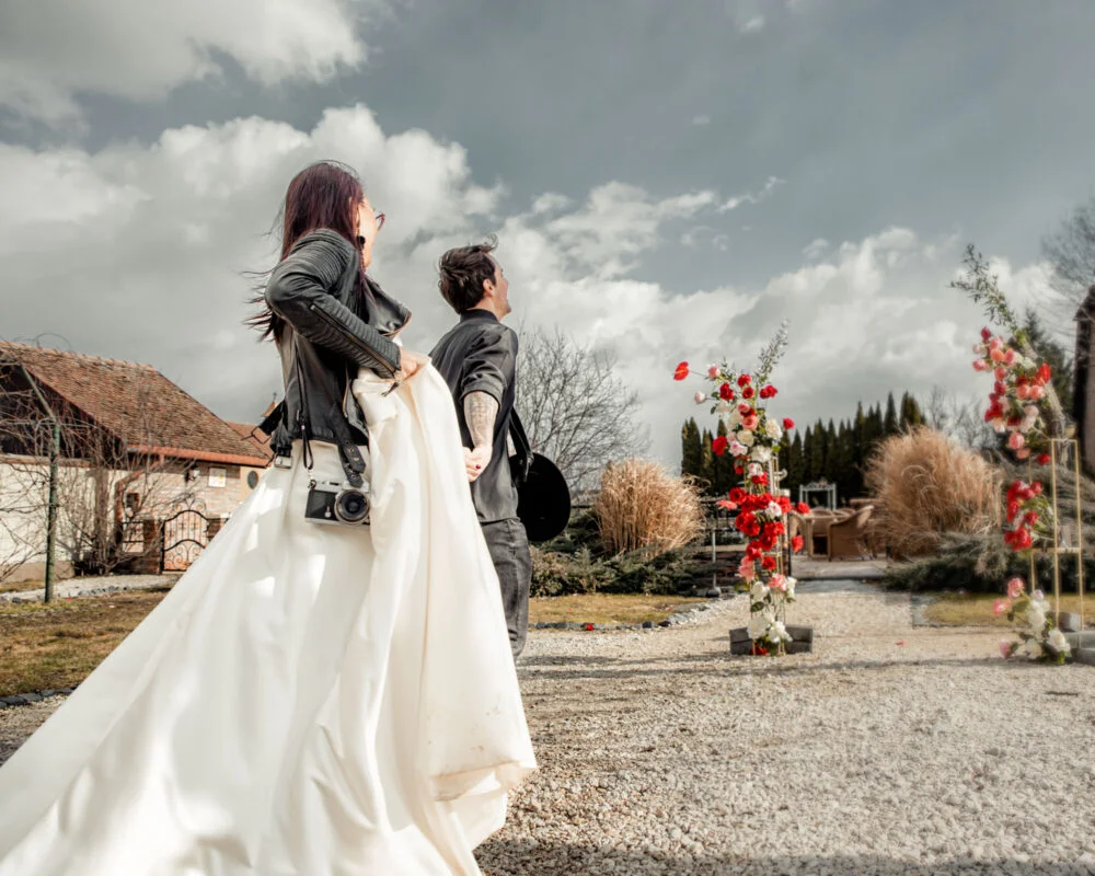 A bride and groom are walking down a path.