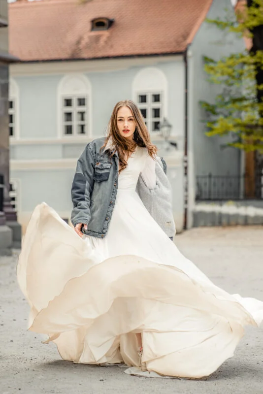 A woman in a white wedding dress is walking down the street.