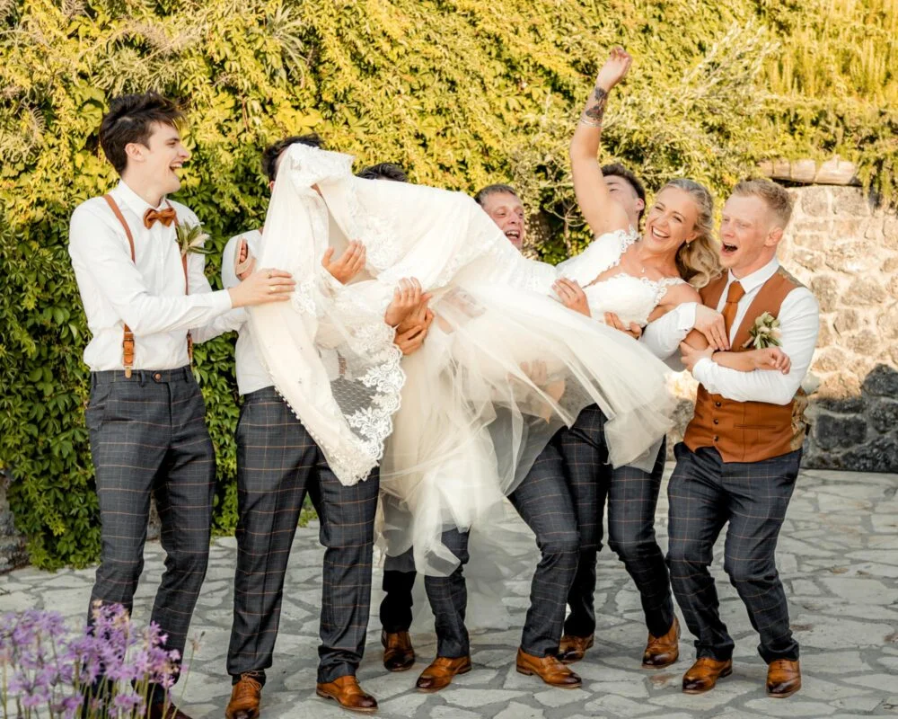 A bride being carried by her bridesmaids.