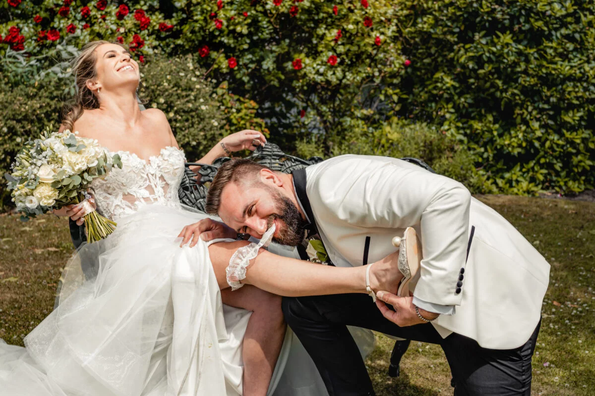 A bride and groom posing for a photo in a garden.