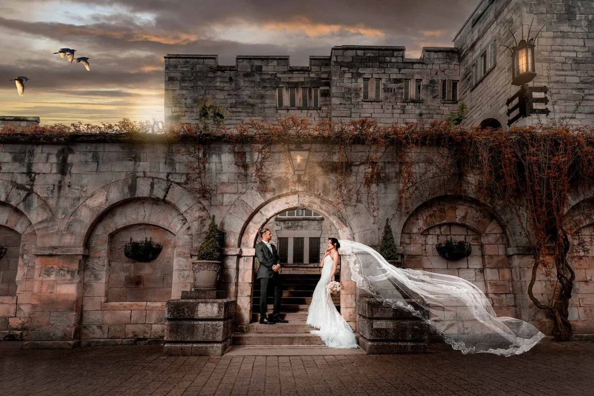 A bride and groom standing in front of a castle.