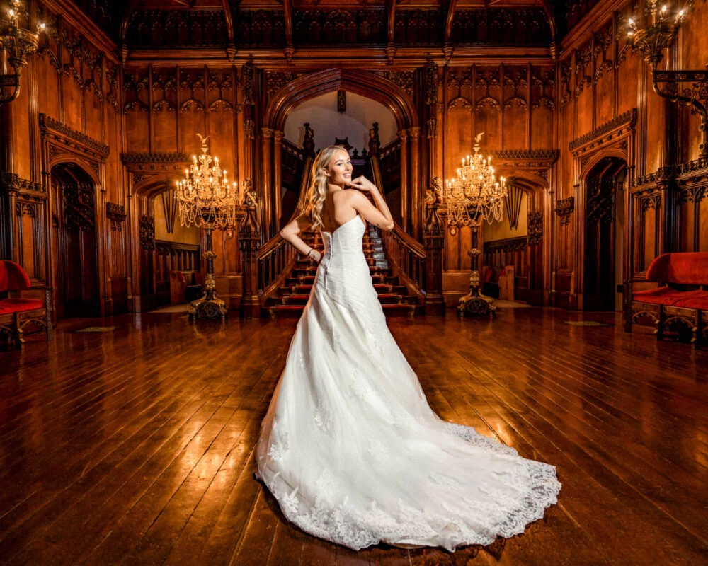 A bride in a wedding dress standing in an ornate room.