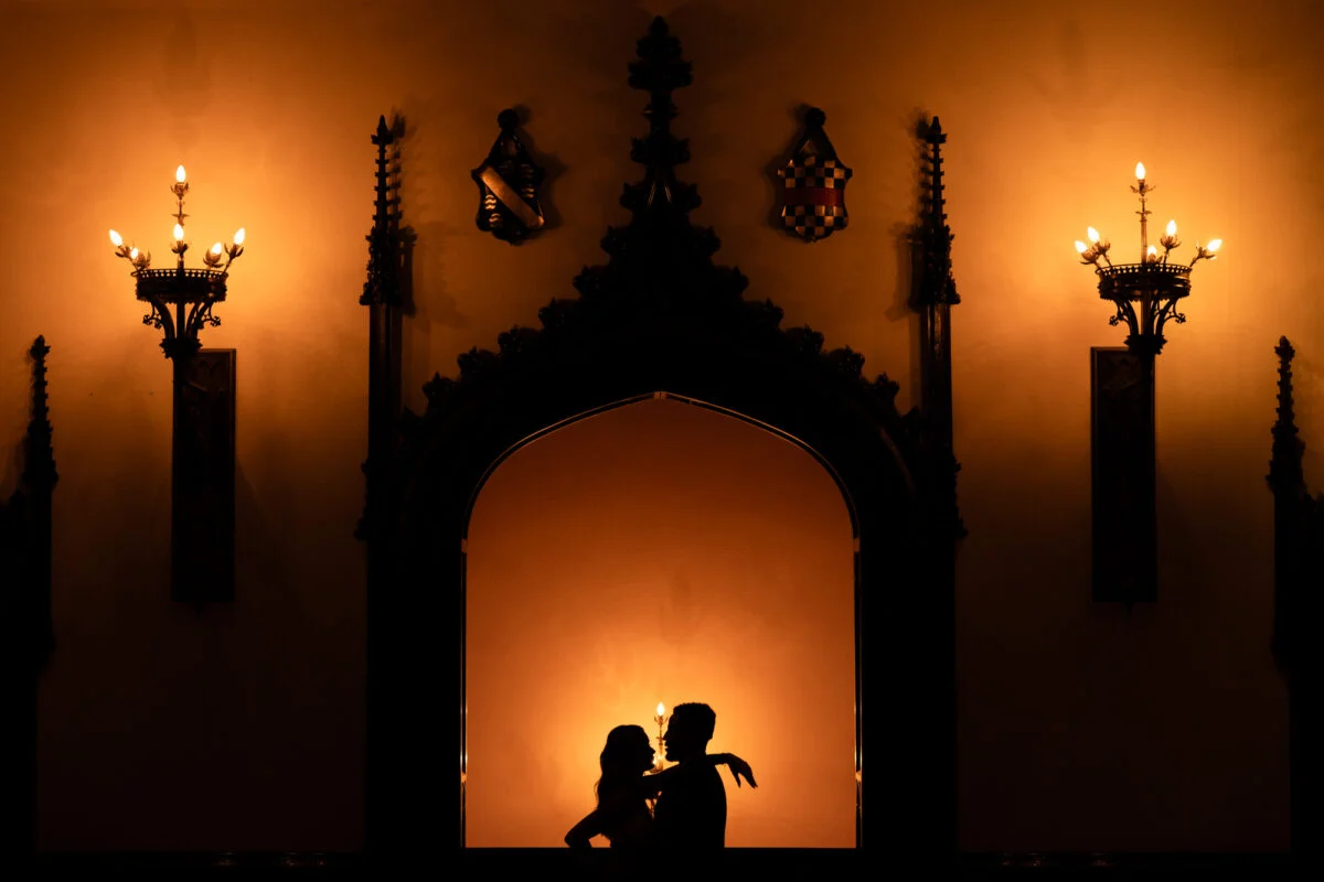 A silhouette of a couple in front of an ornate door.