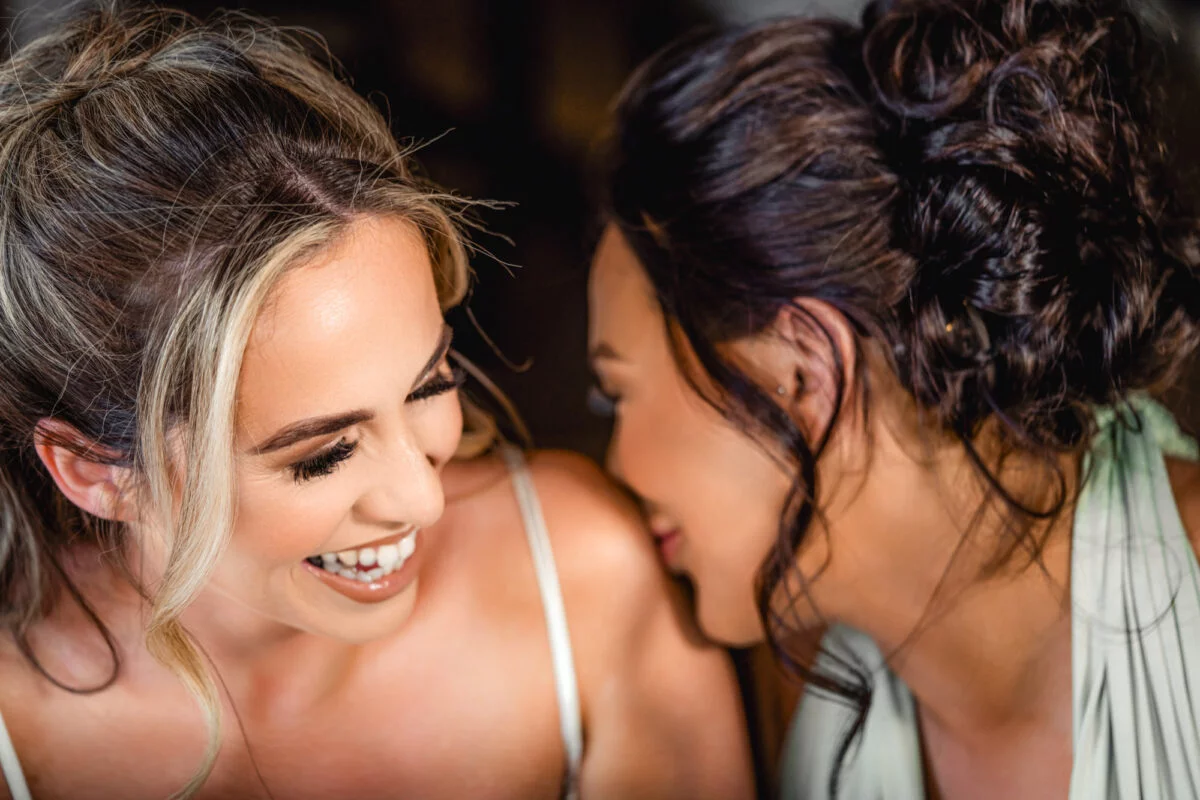 Two brides laughing at each other.