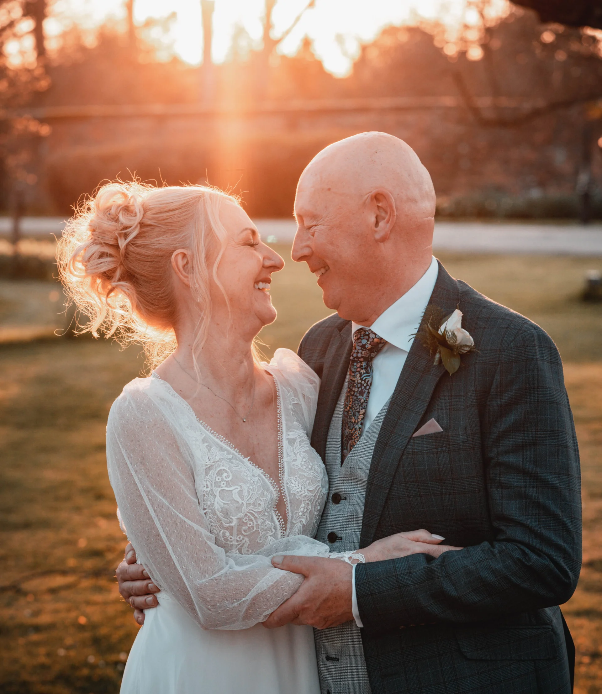A fairytale bride and groom hugging at sunset in front of a tree. (listing)