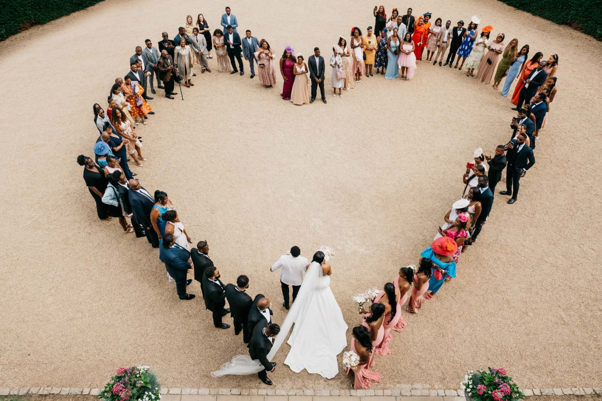 A fairytale wedding party standing in a heart shape. (listing)