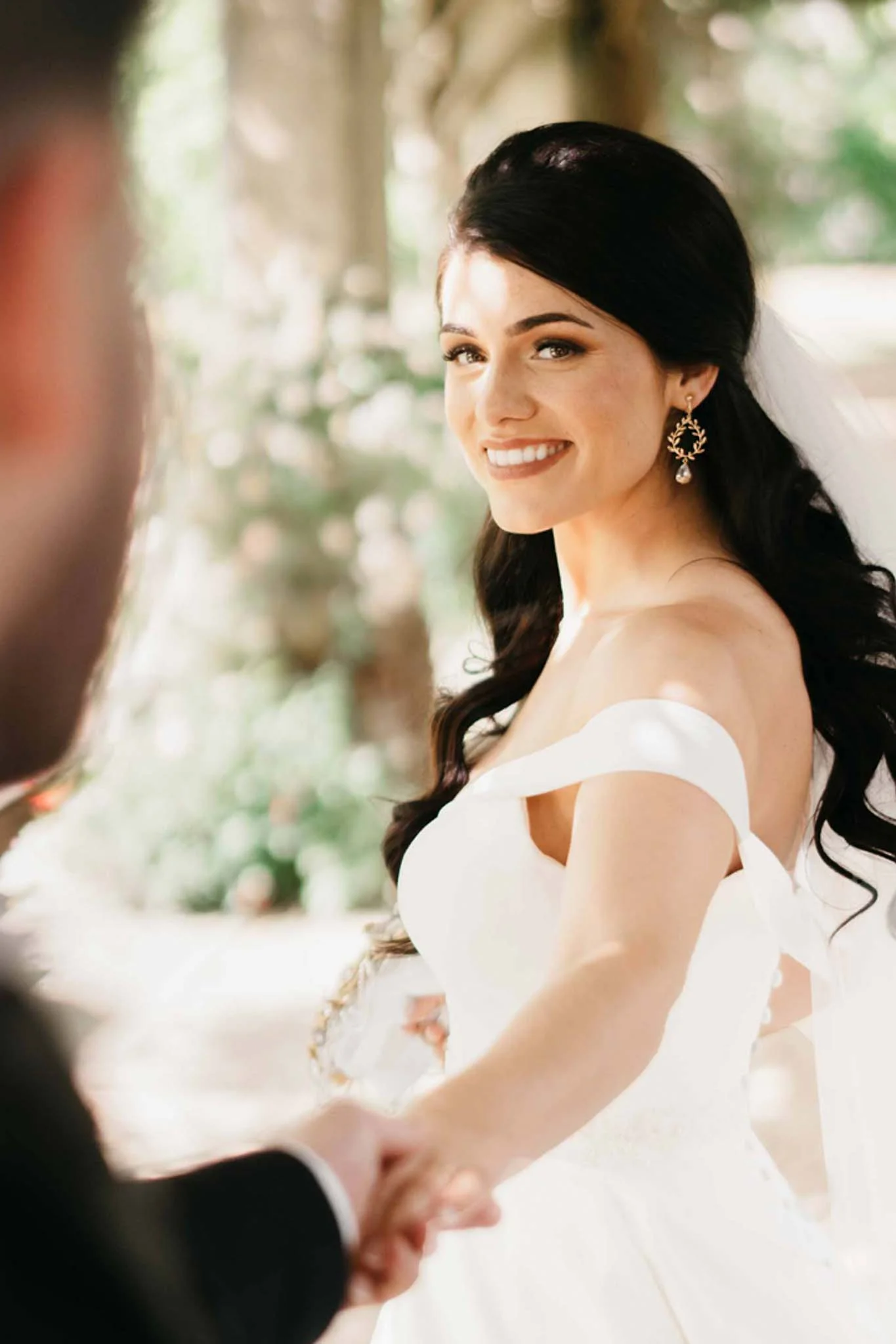 A fairytale bride and groom holding hands in a garden. (listing)