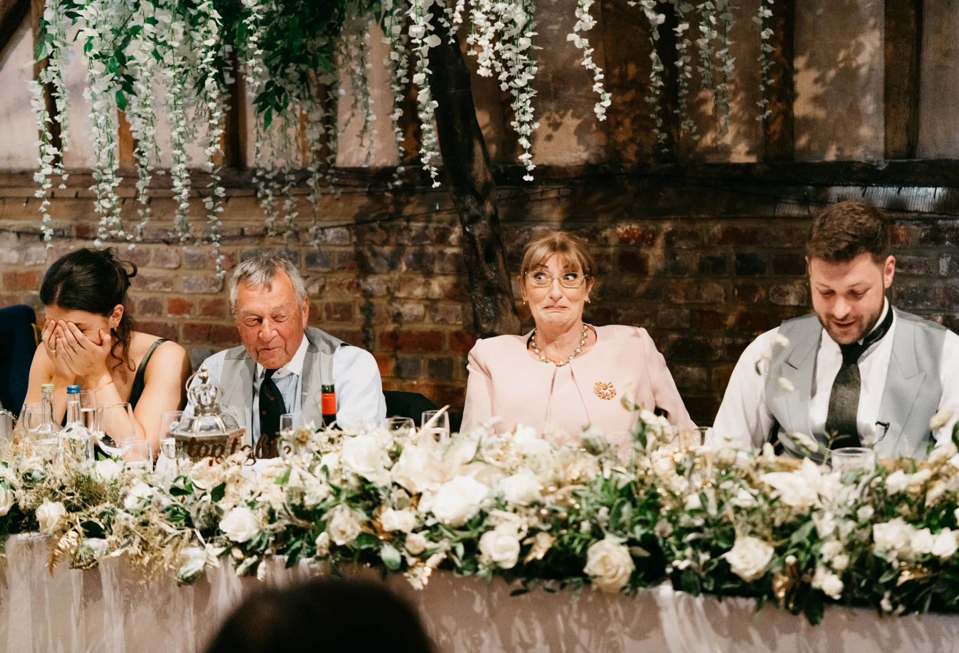 A group of people sitting at a table at a fairytale wedding reception. (listing)