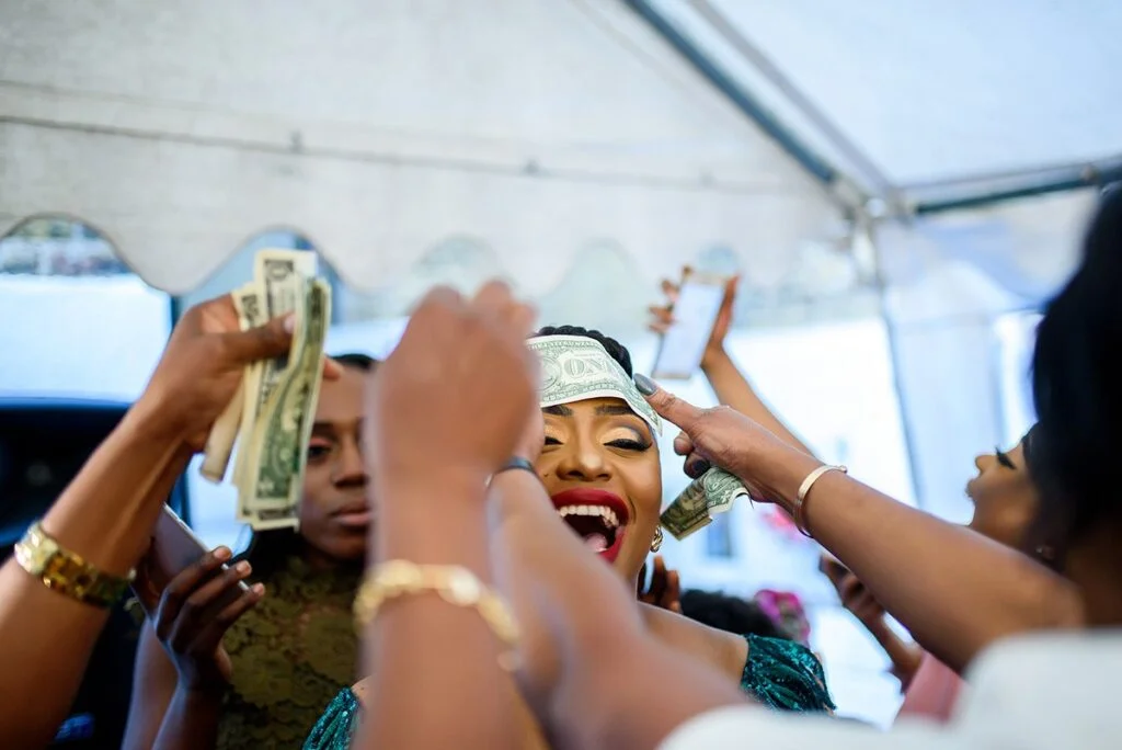 A woman putting money on a woman's head.