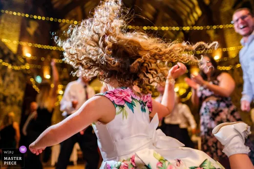 A little girl dancing at a wedding reception.