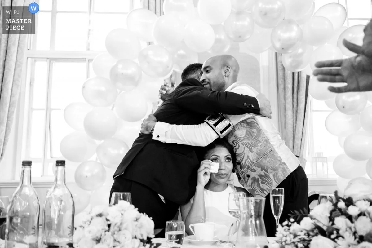 A bride and groom hugging at a wedding reception.