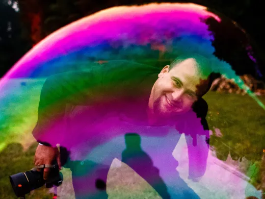 A man standing in front of a colorful soap bubble.