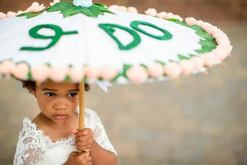 A little girl holding an umbrella with the word do.