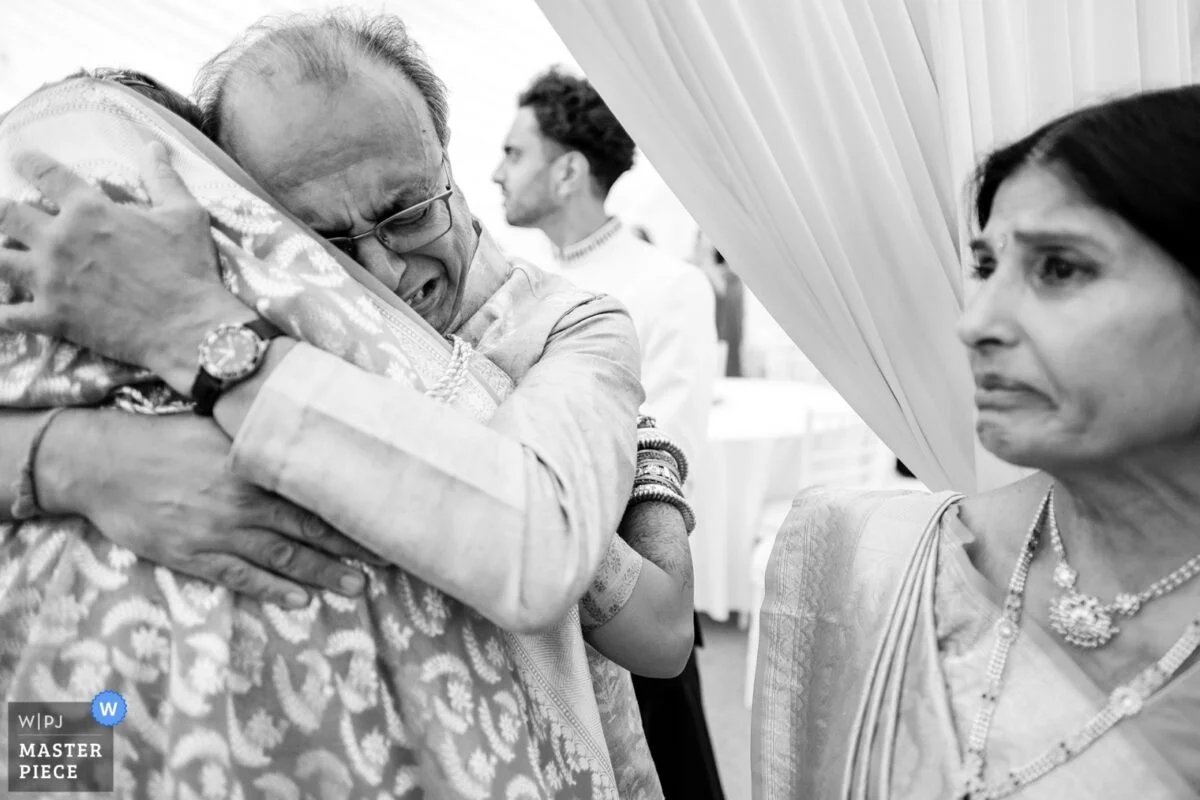 A man is hugging an older woman at a wedding.