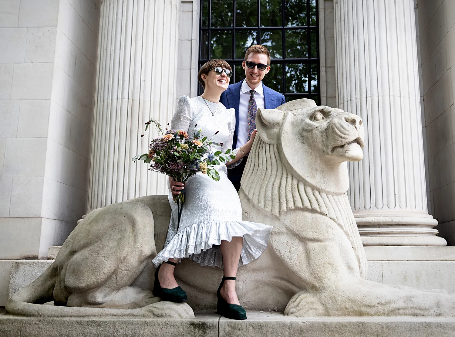 Bride-and-groom-laugh-on-lion-statue-Old-Marylebone-Town-Hall-wedding-close-small (listing)