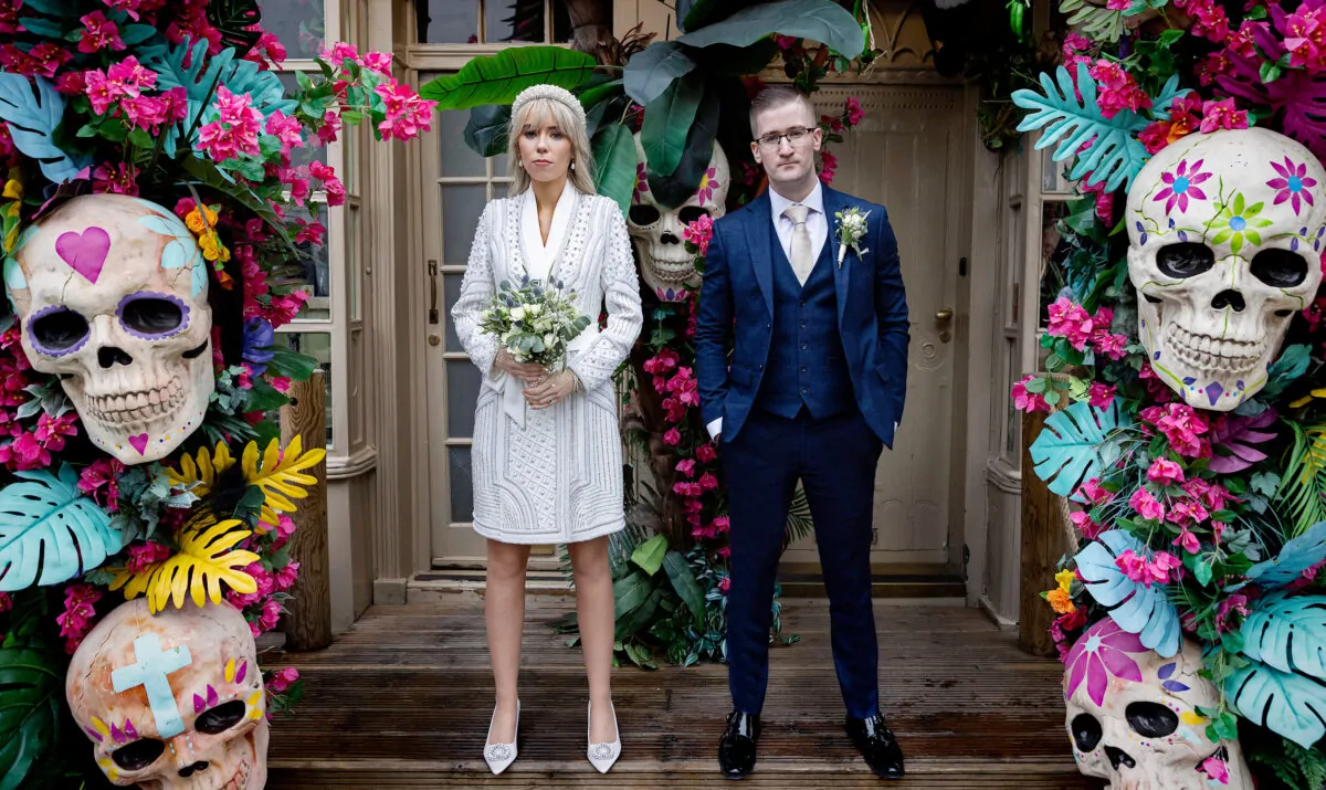 Chelsea-Old-Town-Hall-Wedding-couple-stand-by-Mexican-skulls-Kings-Road