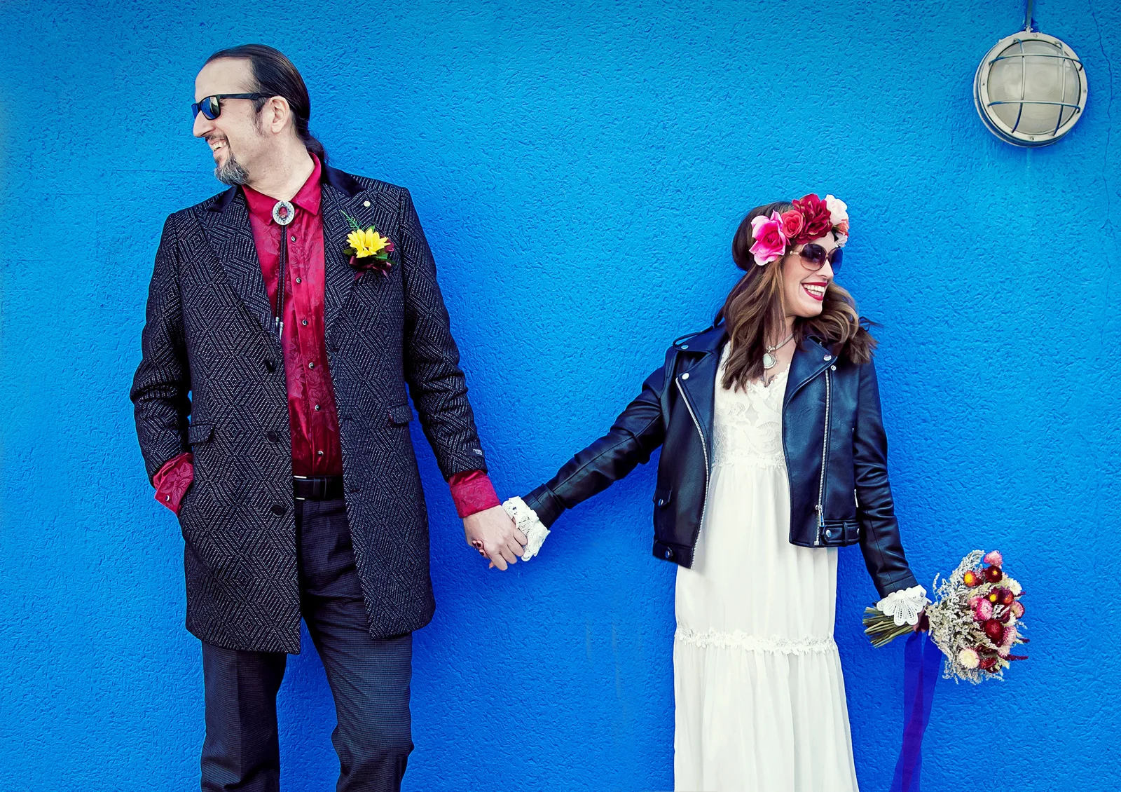 Islington-bride-and-groom-hand-in-hand-by-blue-wall-image (listing)
