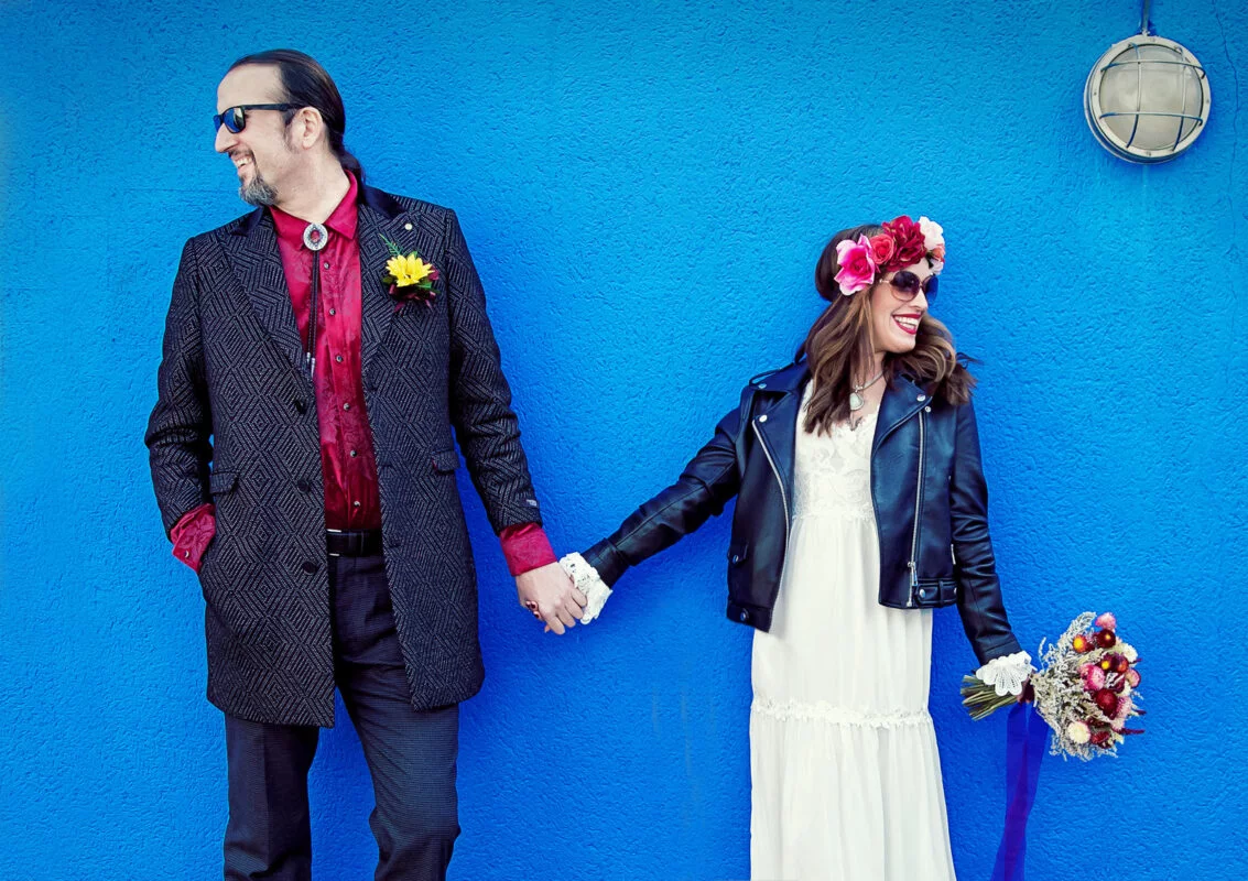 Islington-bride-and-groom-hand-in-hand-by-blue-wall-image