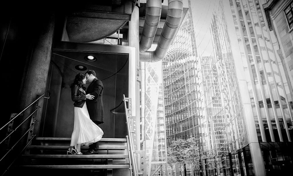 A bride and groom kissing on the steps of a building.