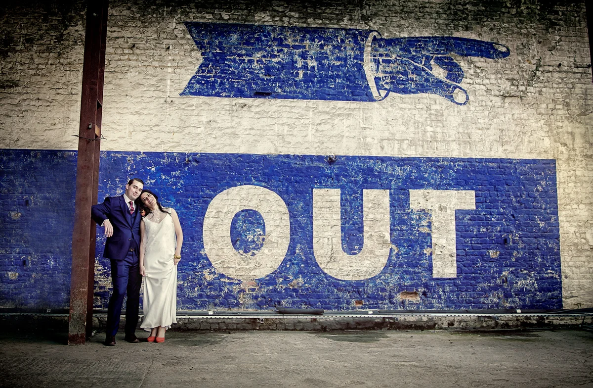 Bride-and-groom-by-sign-at-Trinity-Buoy-Wharf-Wedding-crop (listing)