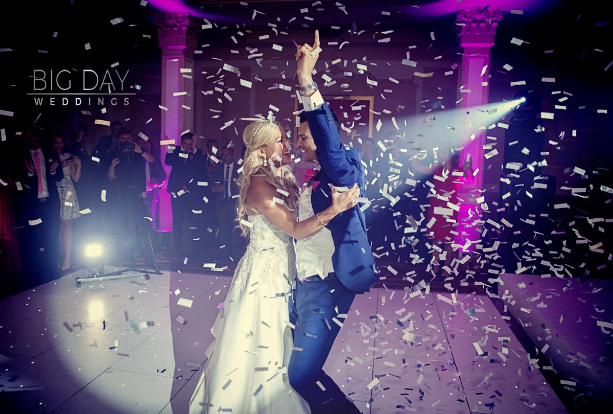 A wedding photographer duo capturing a bride and groom dancing with confetti at their wedding. (listing)