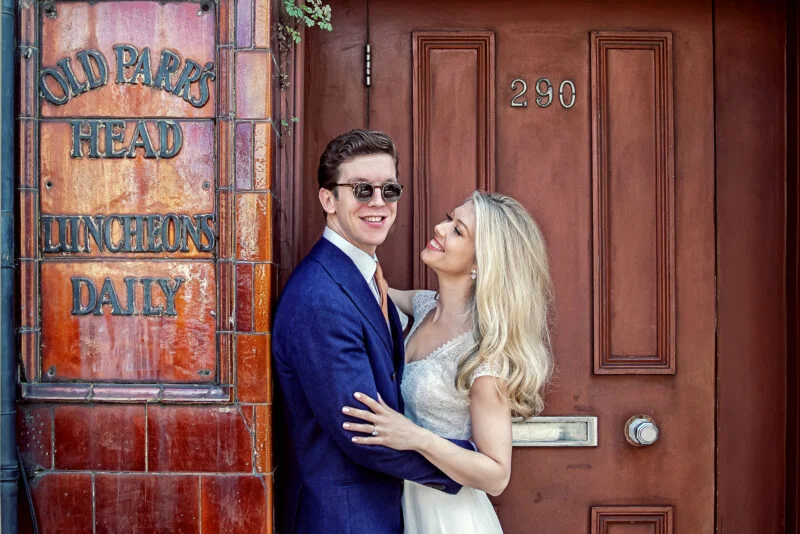 A bride and groom posing in front of a door.