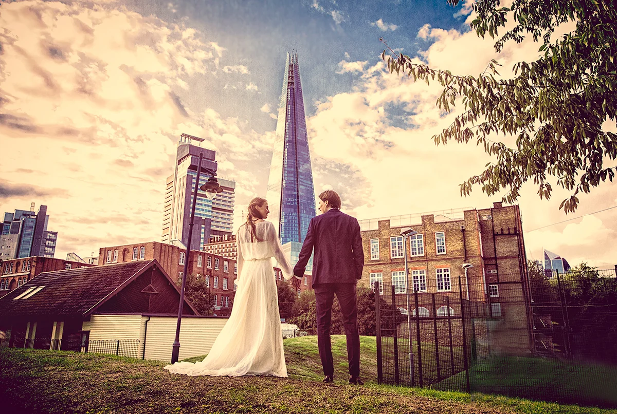 A wedding photographer duo capturing a bride and groom in front of the shard. (listing)