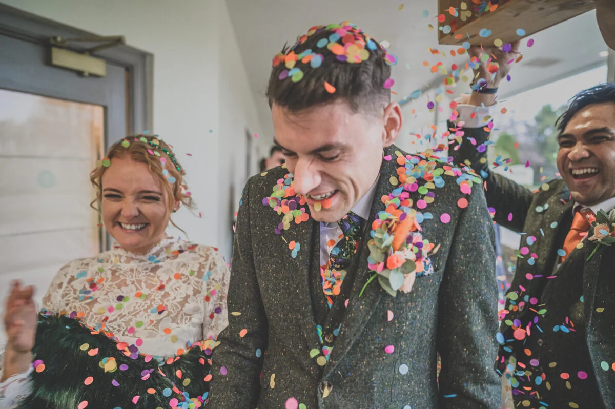 Confetti being thrown at a bride and groom.