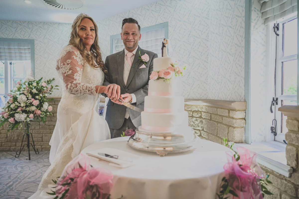 A bride and groom cutting their wedding cake.