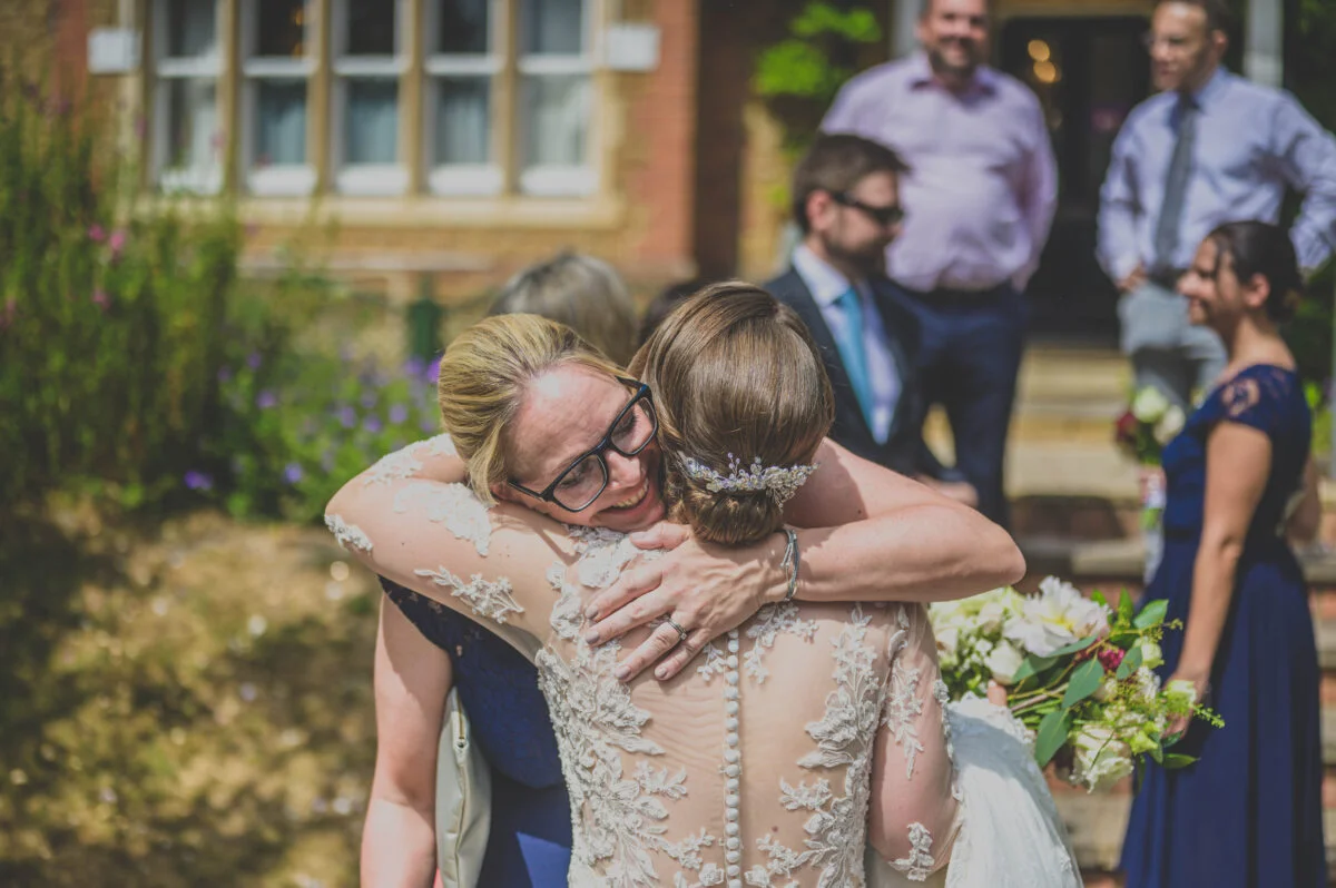 A bride is hugging her bridesmaid after the ceremony.