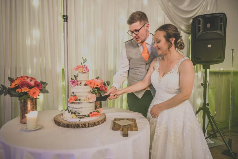A bride and groom cutting their wedding cake.