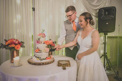 A bride and groom cutting their wedding cake.
