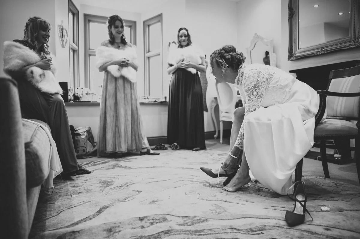 A bride getting ready in front of her bridesmaids.