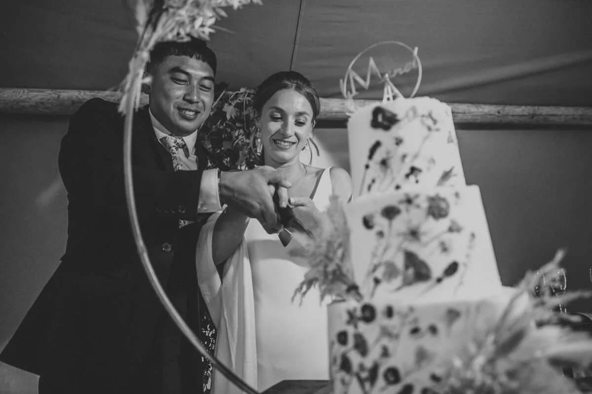 A bride and groom cutting their wedding cake.