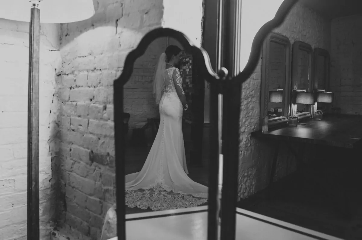 A bride is standing in front of a mirror.