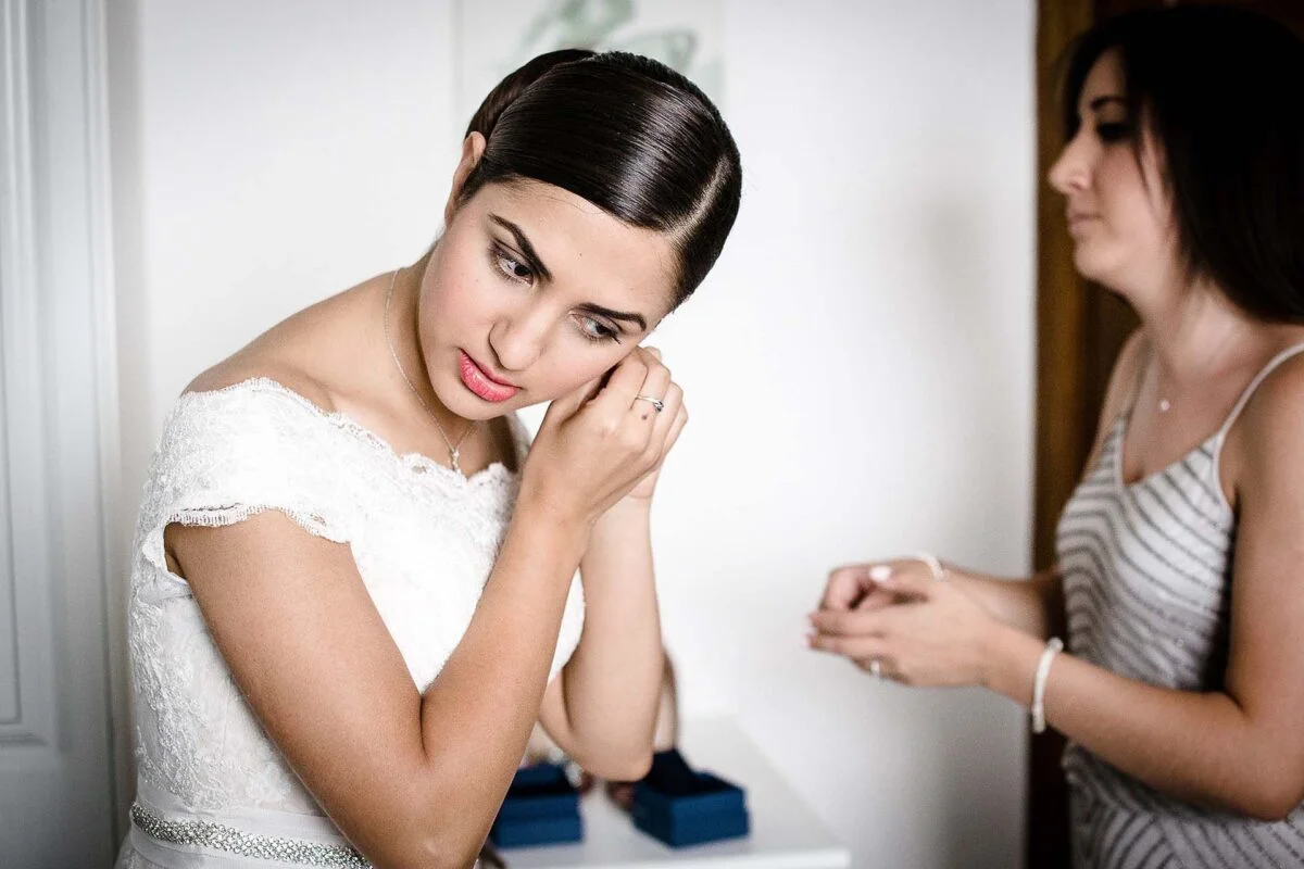 bride_putting_earrings_on-2x-9fc8357d