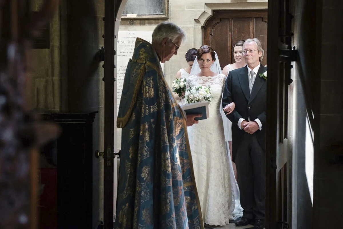 A bride and groom standing in the doorway of a church.