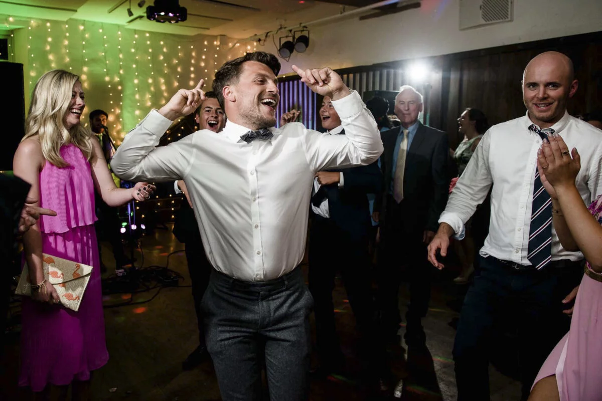 A man dancing on the dance floor at a wedding.