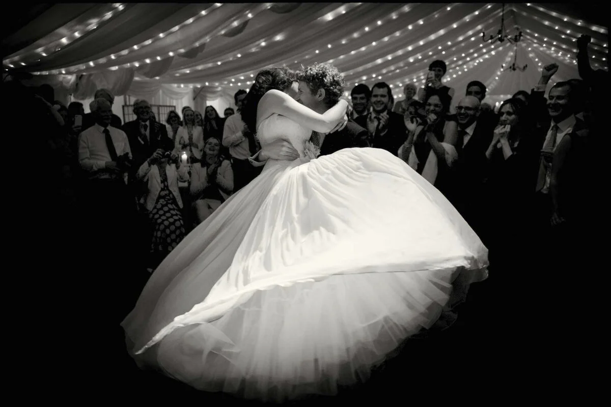 A bride and groom dancing in a wedding tent.