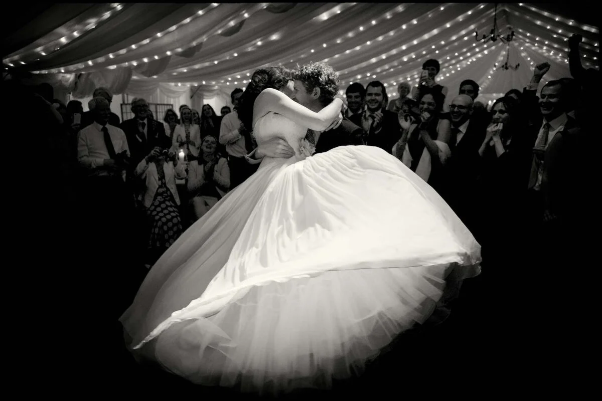 A bride and groom dancing in a tent.