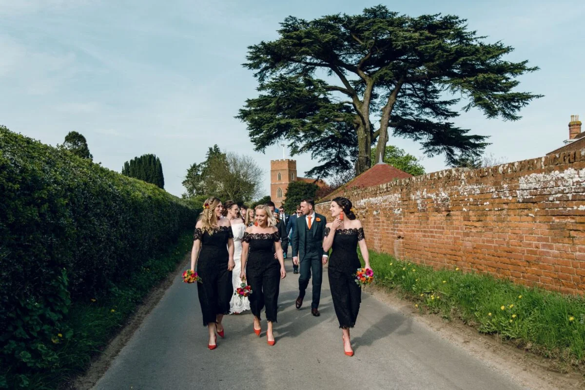 A group of bridesmaids walking down a country road.