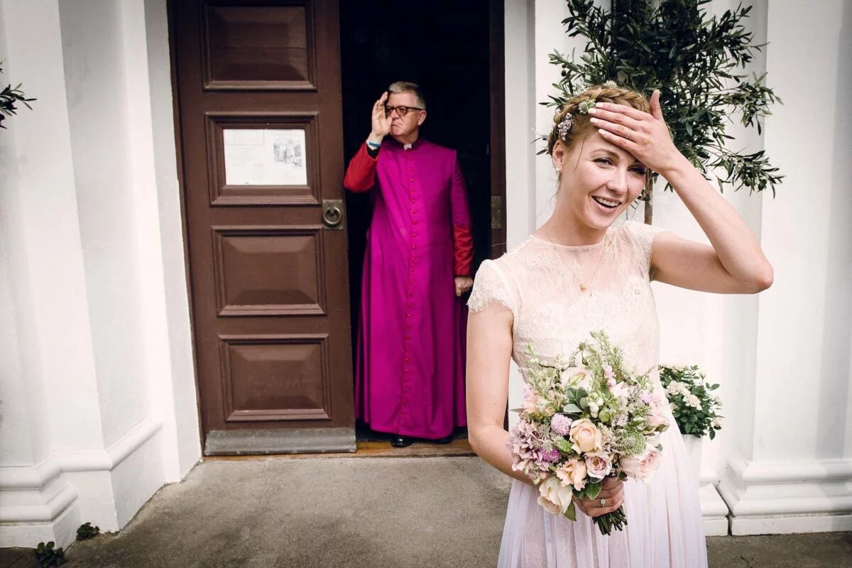 A bride in a purple robe is standing in front of a door.