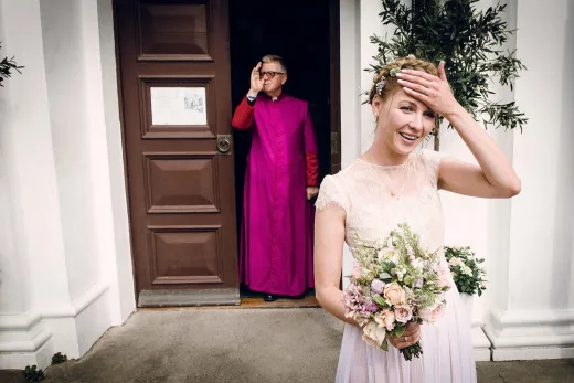 A bride in a purple robe is standing in front of a door.