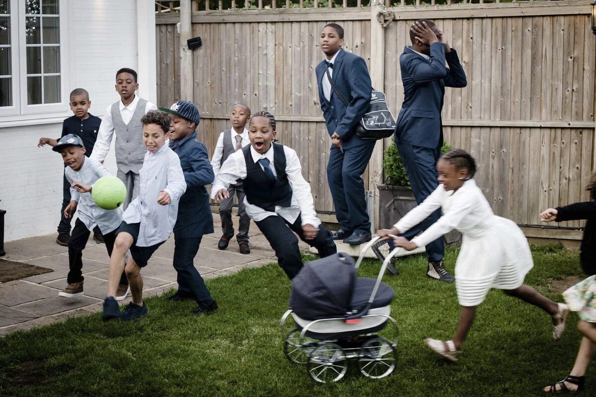 A group of children playing with a stroller in a backyard.