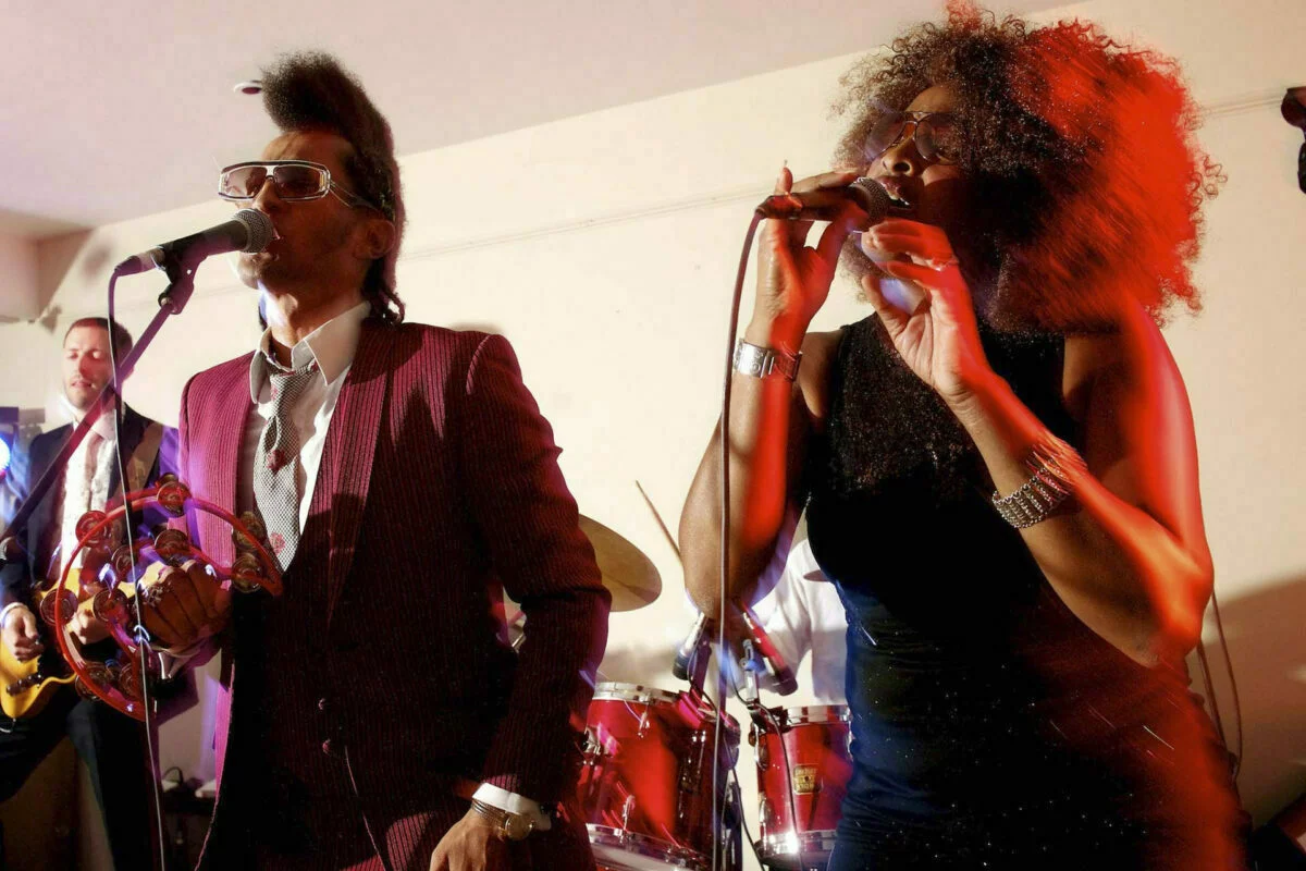 A group of people singing into microphones at a party.