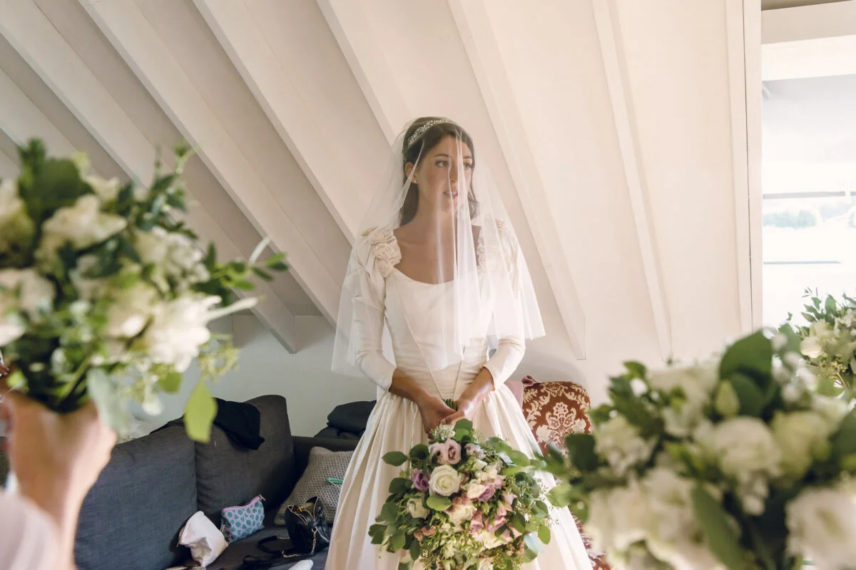 A bride in a wedding dress is holding her bouquet.