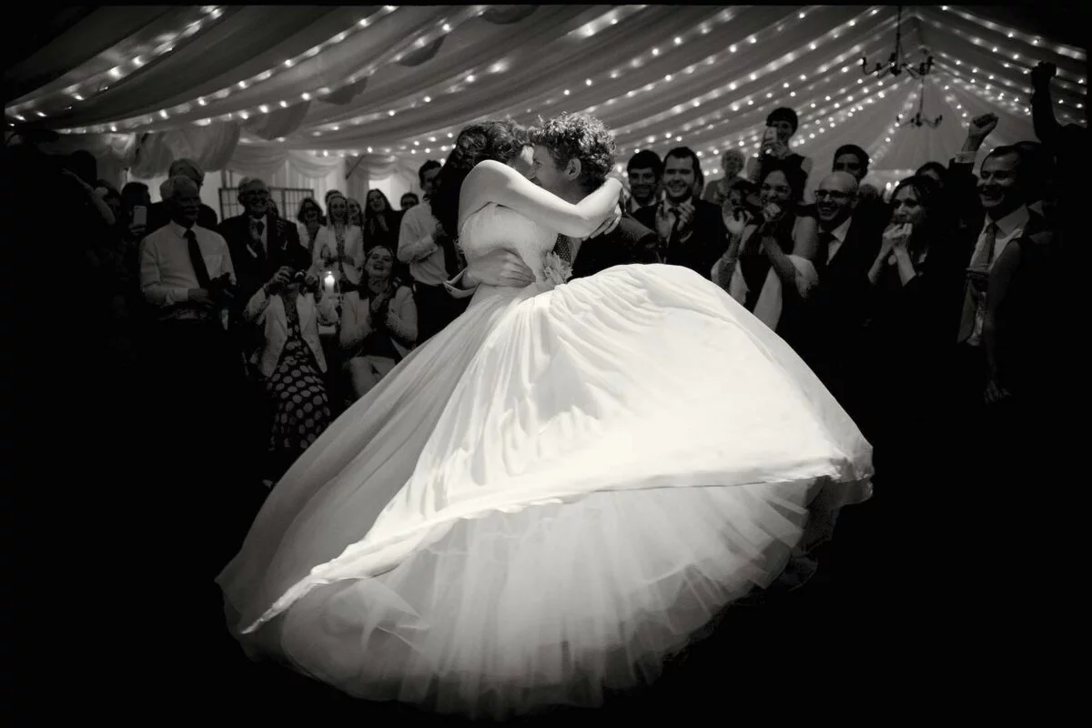 A bride and groom dancing in a wedding tent.