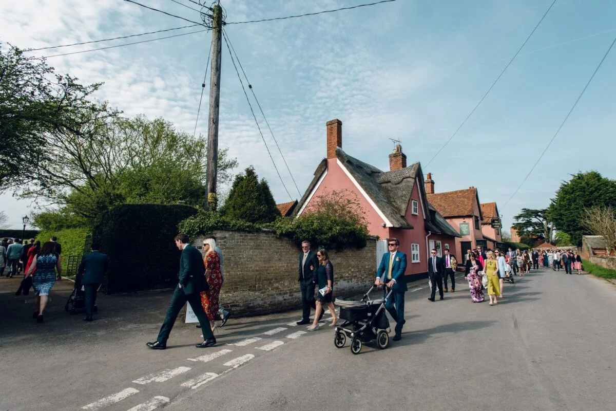 wedding_guests_walking_to_church-2x-9361548d