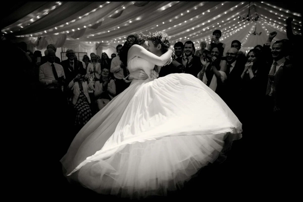 A bride and groom dancing in a tent.