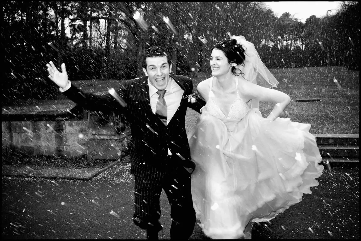 A black and white photo of a bride and groom in the snow.